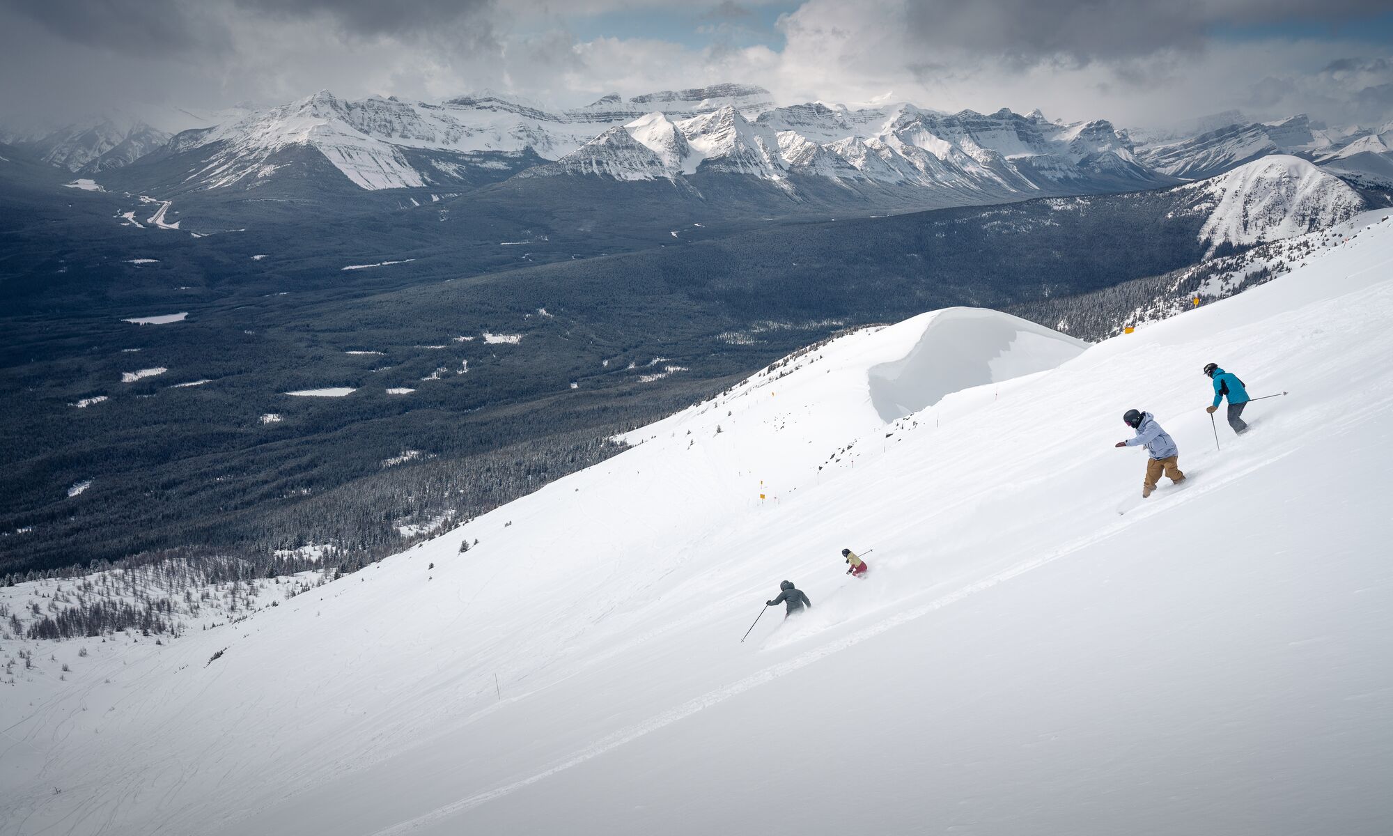 Skiers and snowboarders head down the West Bowl at Lake Louise Ski Resort in Banff National Park